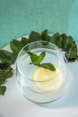 Tasty and healthy lemonade. Refreshing and energizing drink made with lemon and mint placed on a green background.
