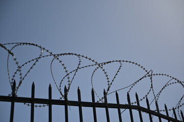 A black protection fence with military barbed wire nearby the Acropolis in Athens-Greece. 