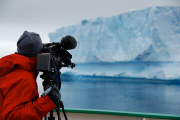 Obraz na płótnie Canvas Photographer filming an iceberg