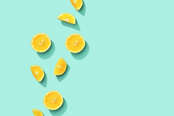 Citrus lemon fruit as creative background, slices of citrus with hard shadows at sunlight on pastel mint background with copy space. Healthy fruits food concept. Flat lay, top view - obrazy, fototapety, plakaty