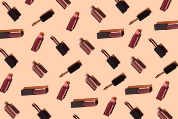 Creative pattern made of colorful liquid lipstick or lip gloss. Set of decorative cosmetics on colorful background. Make up and fashion concept. Top view. Flat lay.