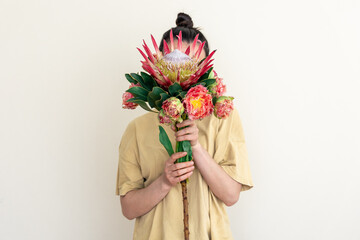 A young woman with protea flower on a white background.