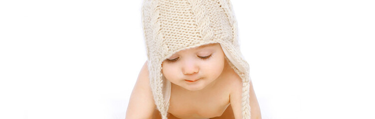 Portrait close up of cute baby crawling wearing winter knitted hat on white background