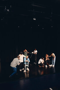 Actors and actresses rehearsing together on stage