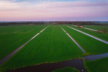 Obraz premium Aerial view of a village and farm agriculture fields in the countryside in Netherlands