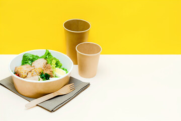 Healthy food lunch in kraft paper carton eco friendly box disposable bowl packaging container, cup on yellow background. chicken, eggs, greens. Take away delivery. environment protection copy space