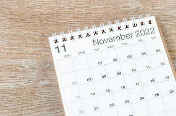 November 2022 desk calendar on wooden background.