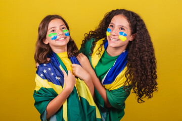 sisters and friends cheering brazil, soccer fans, smiling and cheering, having fun watching brazil...