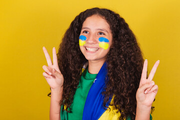 Brazilian, Caucasian girl, soccer fan, close-up photo, expression of peace and love, fingers...