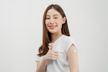 Portrait of pretty, beautiful asian young, teenage attractive after getting, receive anti virus vaccine covid-19. Showing arm on white bandage isolated on white background, copy space.