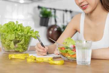 Diet, Dieting asian young woman working, write diet plan right nutrition, vegetables salad is food...