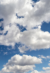 White curly clouds in the blue sky, vertical format