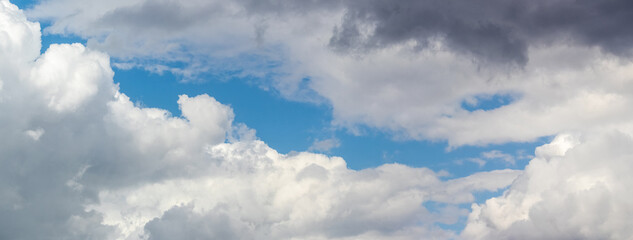 A black cloud hung over the white curly clouds in the blue sky