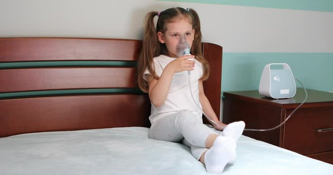 Girl making inhalation with nebulizer at home.
