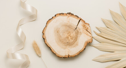 Wooden summer podium top view with palm leaf and lagurus, beige background, banner size