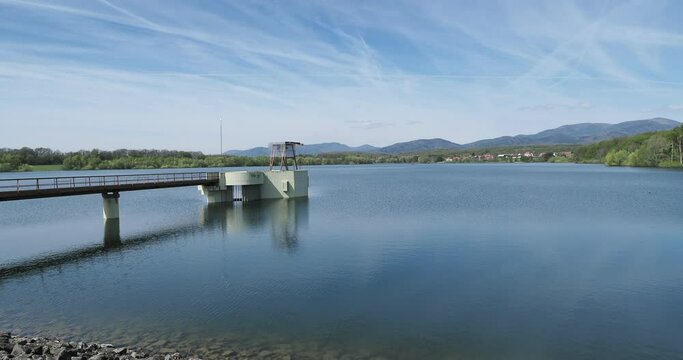 Le barrage de Michelbach et lac artificiel dans le Haut-Rhin en Alsace. Vue sur la retenue d'eau et la tour d'&eacute;vacuation prise d'eau depuis la digue principale et la route de couronnement