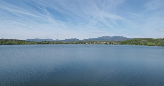 Les eaux calmes du lac et barrage de Michelbach et son village alsacien avec en arriere plan les sommet vosgiens du Rossberg, Waldmatt, Kurrenbourg, Markstein, Croix du Staufen au Grand Ballon 