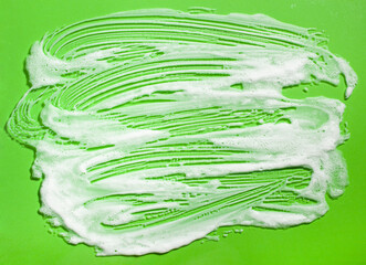 foam soap suds on green background, laundry cleaning washing concept