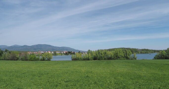 Les eaux calmes du lac de Michelbach dans le Haut-rhin en Alsace. Vue sur la retenue principale et le village depuis le chemin de randonn&eacute;e autour du lac