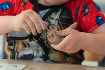a child makes clay crafts with his hands