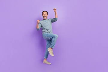 Fototapeta na wymiar Full size photo of ecstatic overjoyed male raise fists in victory triumph win money prize isolated on purple color background