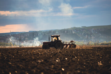 Tractors plowing fields in early spring