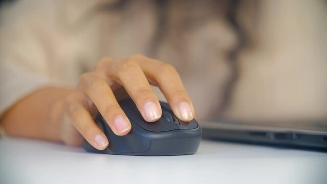 African female person clicking on a wireless computer mouse in close up 4K video clip