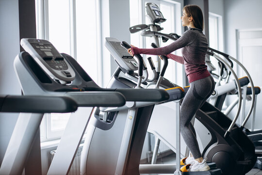 Sporty woman cycling on orbitrek at the gym