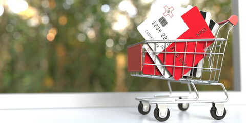 Credit card mockups with flags of Malta in a small shopping cart. Conceptual 3D rendering - obrazy, fototapety, plakaty