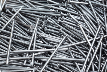 Pile of grey iron nails. Texture nails folded in one pile.