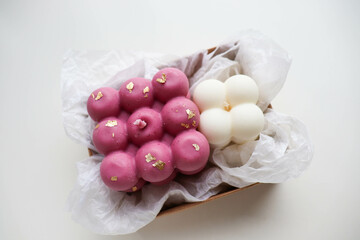 a bouquet of white roses and a handmade candle made of natural soy wax