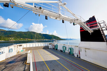 Empty deck of a ferry in the Norwegian Sea, in the background the coast of a Norwegian fjord on a...