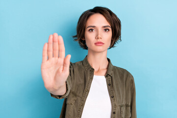 Photo of serious young bob hairdo lady show stop wear khaki shirt isolated on blue color background