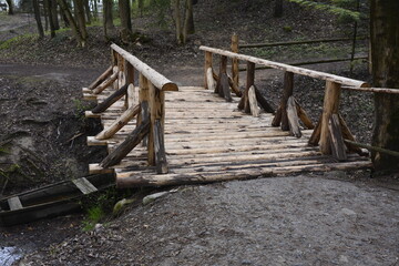 Rustic wooden bridge leading to an orchard.