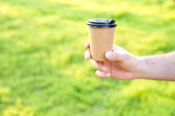 a craft beaker in his hand on a green background. free space for text