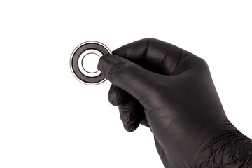 Male hand in nitrile glove holding metal roller bearing. Ball bearing isolated. Super Precision...