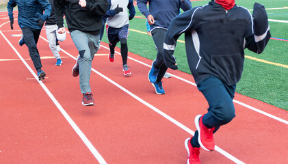 Naklejka premium Group of boys running on a track on a cold day