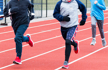 Fototapeta premium Young runners running on a track on a cold day
