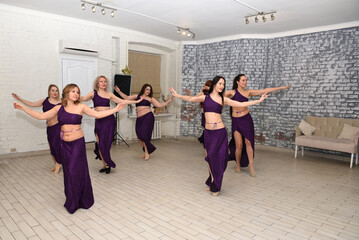 A group of beautiful girls in a choreography studio for training dancing in oriental outfits