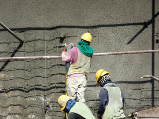SELANGOR, MALAYSIA -MARCH 4: Construction workers are spraying liquid concrete onto the slope...