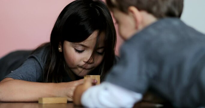 Children playing with domino buildings blocks