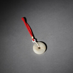Round necklace pendant ,jade amulet jewelry on gray background © Null/Wirestock Creators