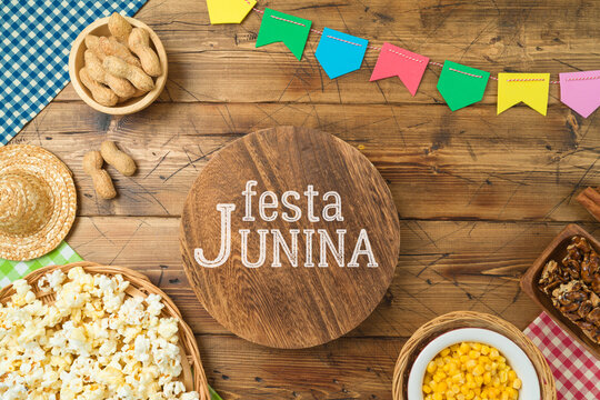 Festa Junina party background with wooden board and traditional food. Brazilian summer harvest festival concept. Top view, flat lay