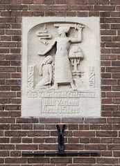 Second World War Memorial Stone Tablet on the Exterior Facade of the Boomkerk Church in Amsterdam Depicting a Man Holding a Sword, a Woman, a Tree and a Snake, Netherlands