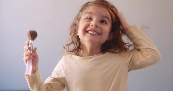 Cute toddler girl applying makeup by herself. Shot in 4K on a cinema camera.