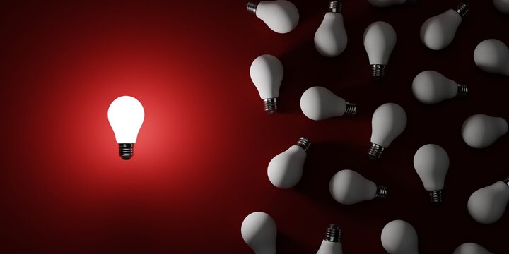 The luminion light bulb lies freely and separately from other white light bulbs on the red surface. 3D render illustration. Banner size.