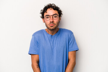 Young caucasian man isolated on white background shrugs shoulders and open eyes confused.
