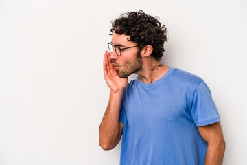 Young caucasian man isolated on white background is saying a secret hot braking news and looking aside