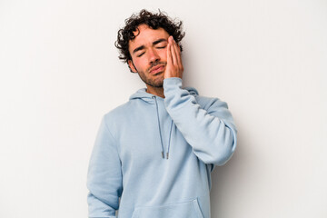 Young caucasian man isolated on white background tired and very sleepy keeping hand on head.