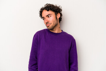 Young caucasian man isolated on white background shrugs shoulders and open eyes confused.